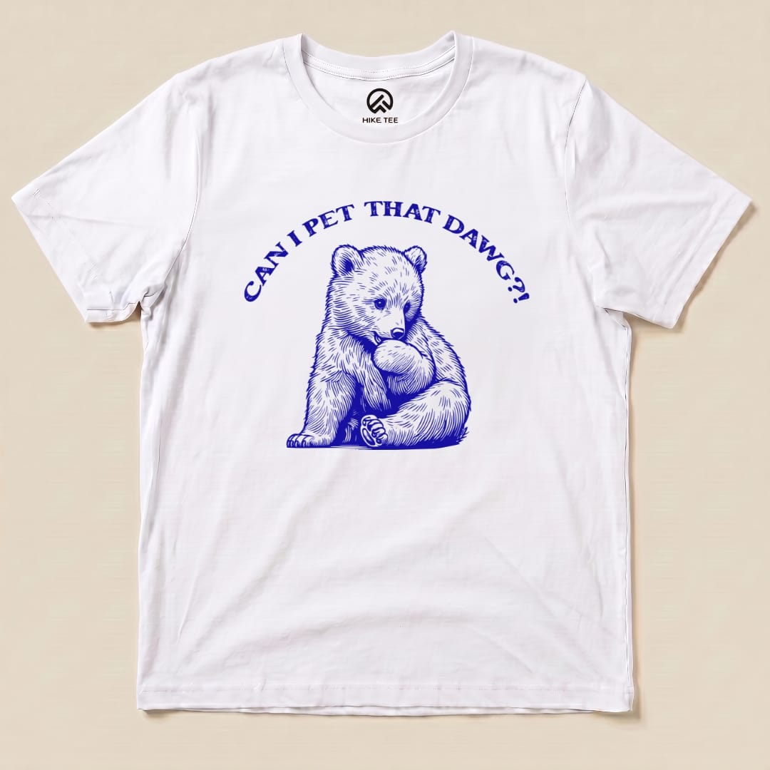 A graphic t-shirt featuring a playful bear illustration and the text "CAN I PET THAT DAWG?!" in bold blue letters.