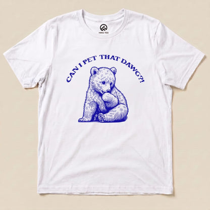 A graphic t-shirt featuring a playful bear illustration and the text "CAN I PET THAT DAWG?!" in bold blue letters.