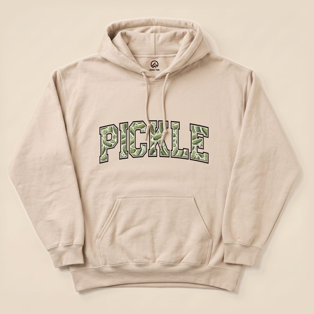 A beige "Pickle Camping Hoodie" featuring bold, green text that spells "PICKLE" in a playful graphic style.