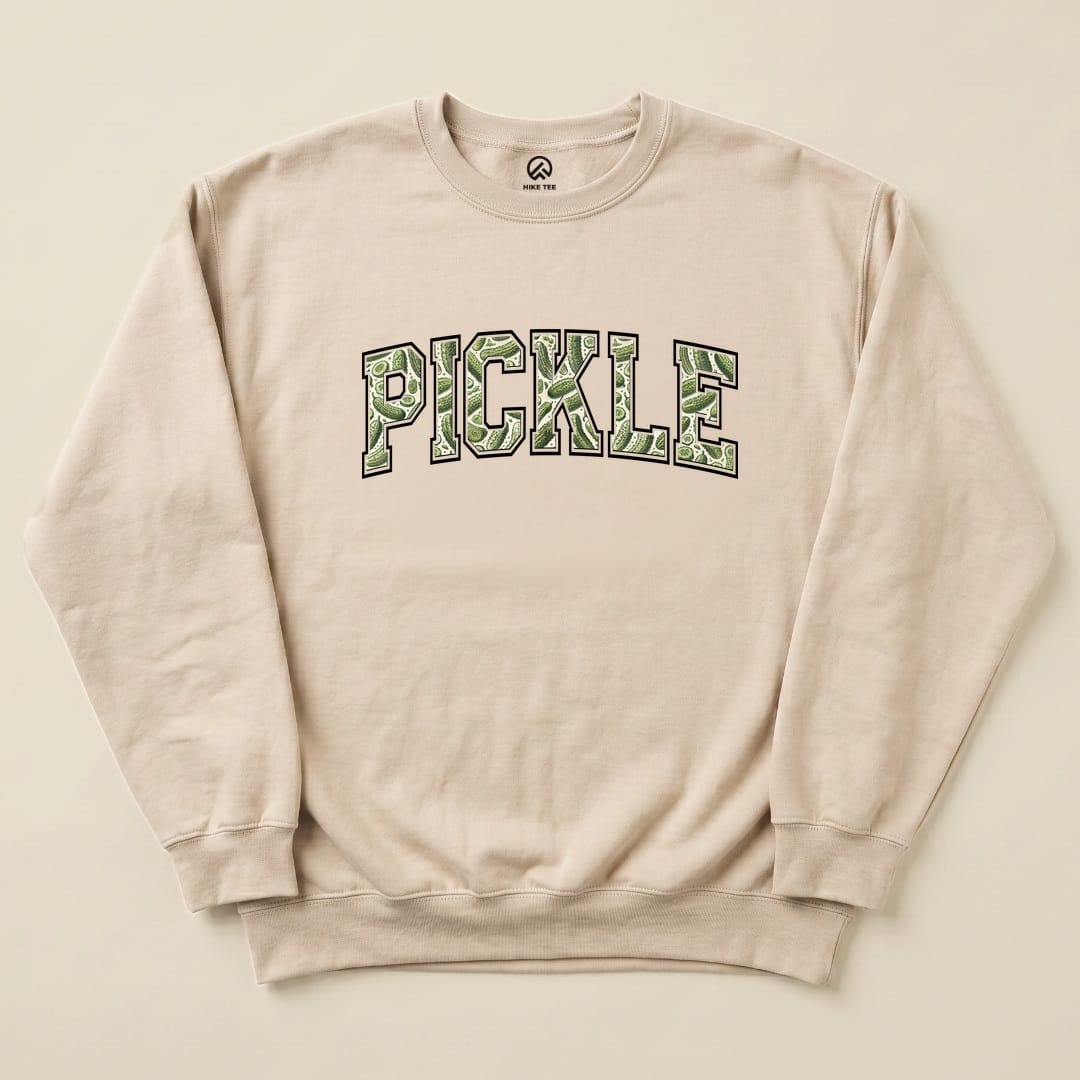 A beige Pickle Camping Sweatshirt featuring oversized "PICKLE" text in a green, pickle-themed graphic design.