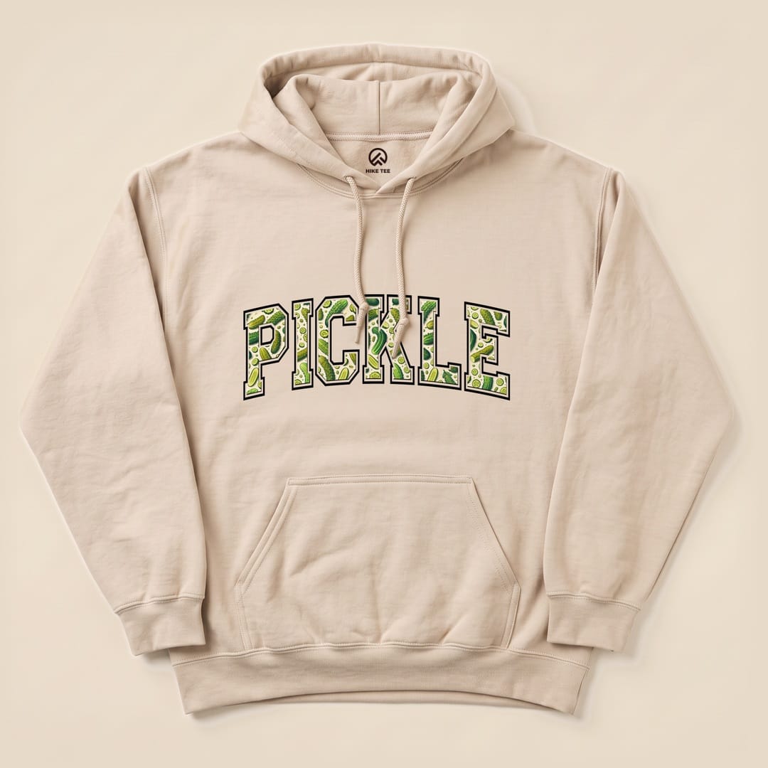 A beige Pickle Hoodie featuring a large, playful graphic of the word "PICKLE" in green, printed on a soft fabric background.