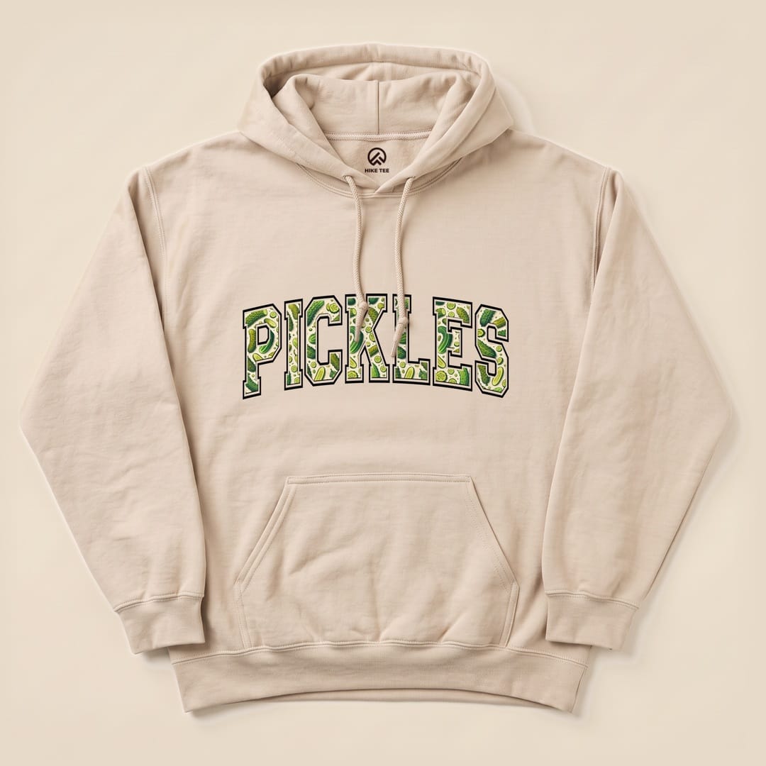 A beige "Pickles Hoodie" featuring bold, green lettering spelling out "PICKLES," designed for a humorous outdoor vibe.