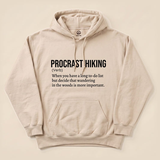 A beige "Procrastihiking Definition Hoodie" features the humorous definition of "procrastihiking" printed in bold black text.