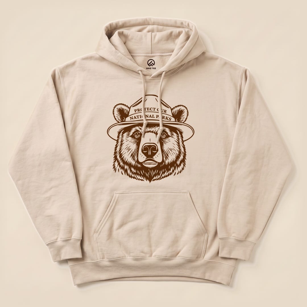 A beige hoodie featuring a graphic of a bear with a ranger hat and the text "Protect Our National Parks".