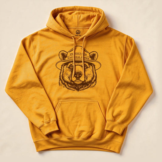 A graphic t-shirt in golden yellow featuring a bear wearing a ranger hat, with the text "Protect Our National Parks.