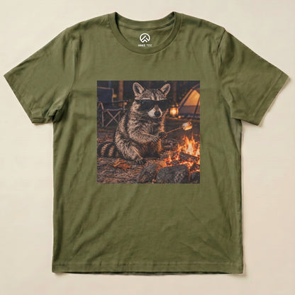 A graphic t-shirt featuring a raccoon in sunglasses sitting by a campfire, holding a marshmallow on a stick.