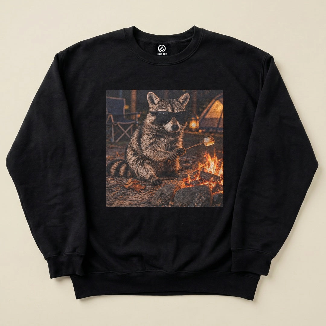 Black Raccoon in Sunglasses Sweatshirt with a raccoon in sunglasses roasting a marshmallow by the campfire graphic