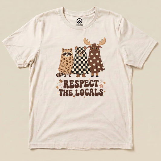 The "Respect the Locals Ghosts Shirt" features three cartoon animals in costumes, showcasing a humorous outdoor theme on a graphic t-shirt.