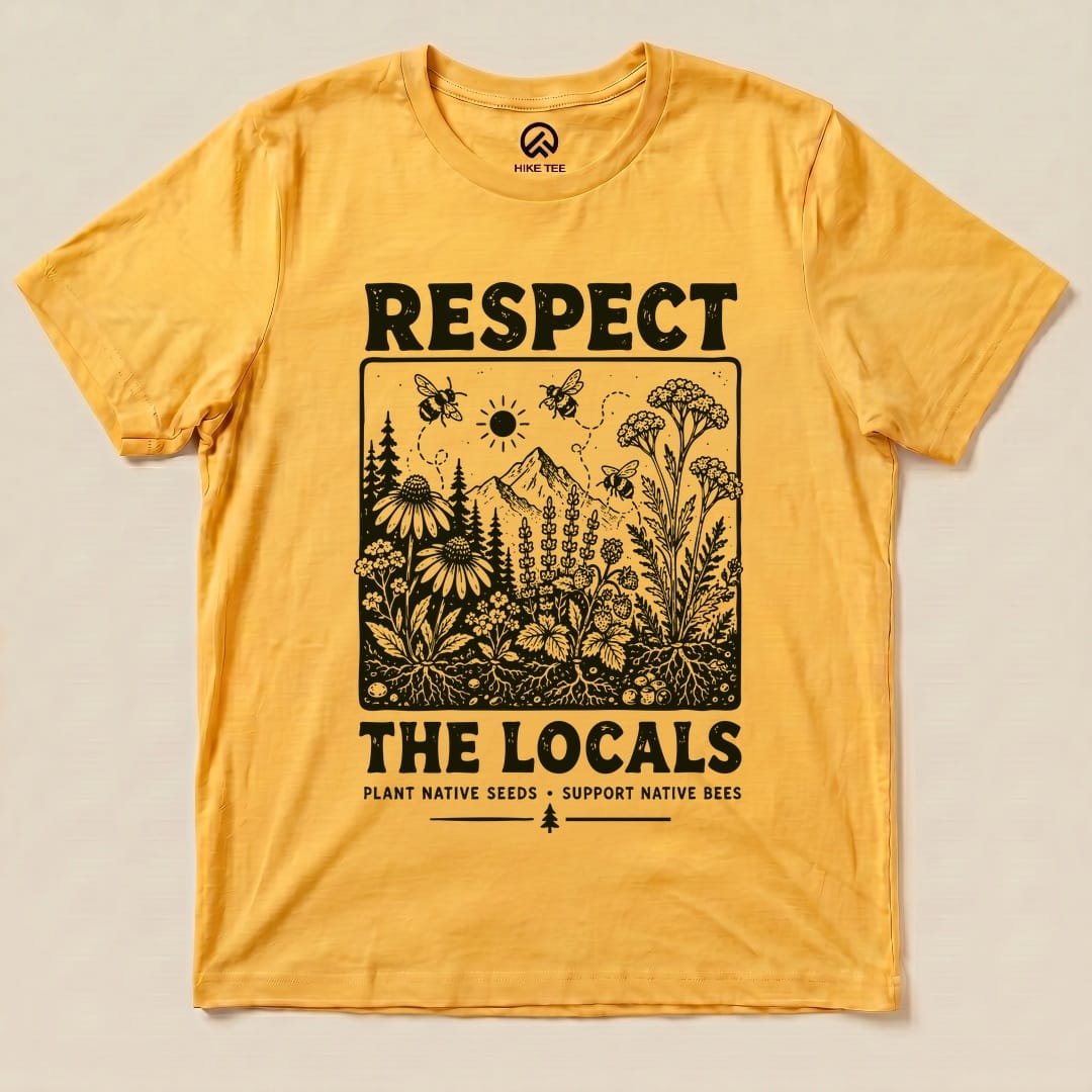 A flat lay of a yellow graphic t-shirt featuring the “Respect The Locals Shirt” design with floral elements and bees.