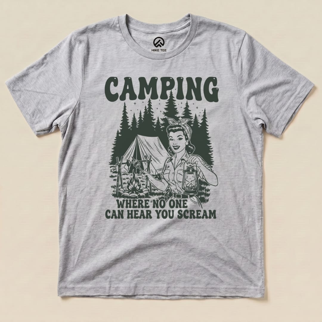 Graphic t-shirt featuring the slogan "Camping Where No One Can Hear You Scream" with a retro camper girl and a tent design.