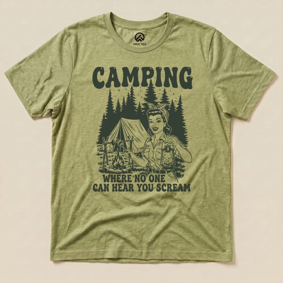 A graphic t-shirt featuring a retro camping scene with a woman holding a lantern and the slogan "Camping: Where No One Can Hear You Scream.