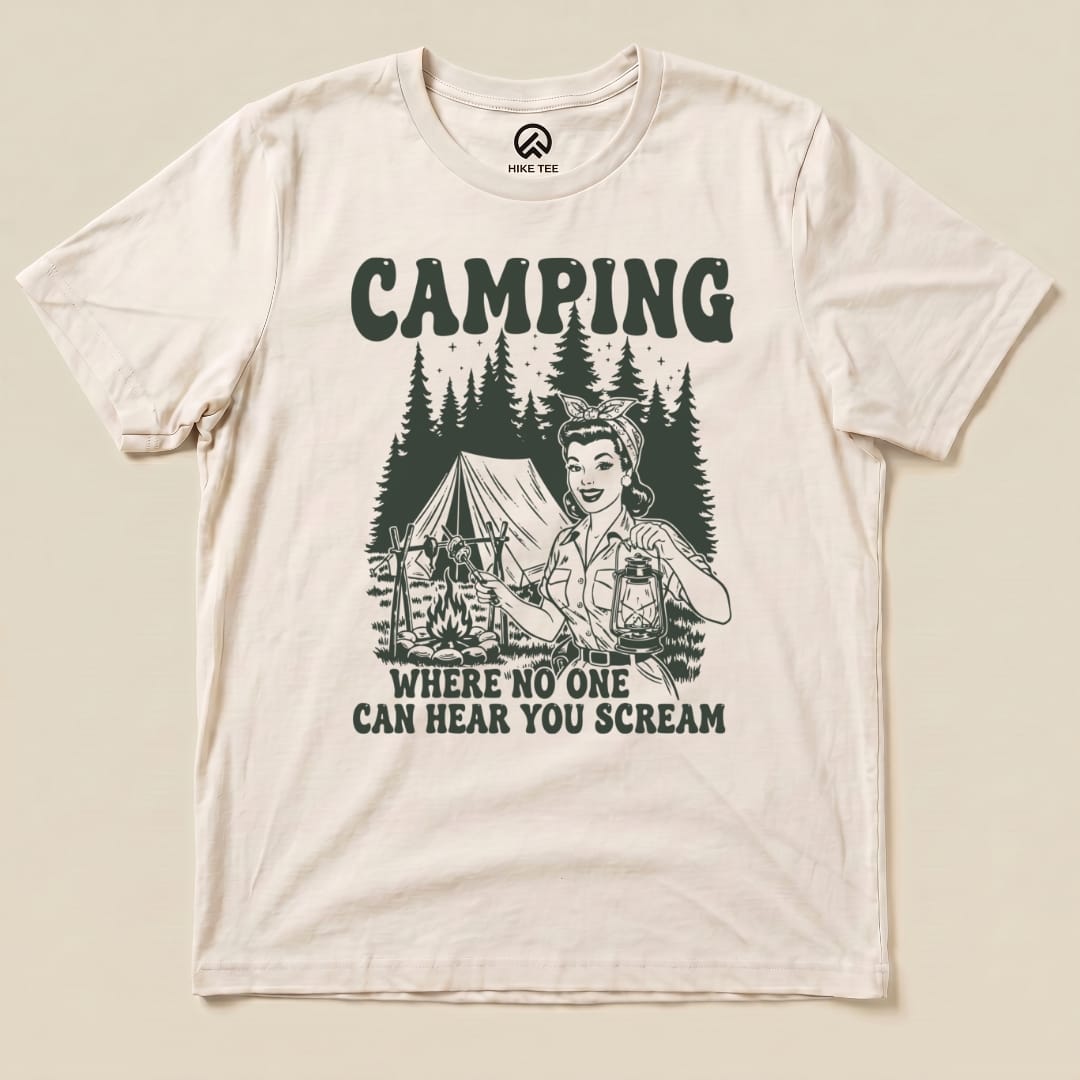 The Retro Camping Scream Shirt features a graphic of a smiling woman holding a lantern in a forest setting with a tent, saying "WHERE NO ONE CAN HEAR YOU SCREAM.