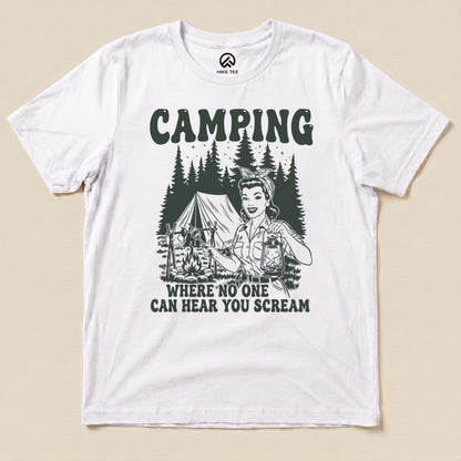 A white graphic t-shirt featuring the "Retro Camping Scream Shirt" design, showcasing a nostalgic illustration of a woman in a camping scene with the phrase "CAMPING WHERE NO ONE CAN HEAR YOU SCREAM.