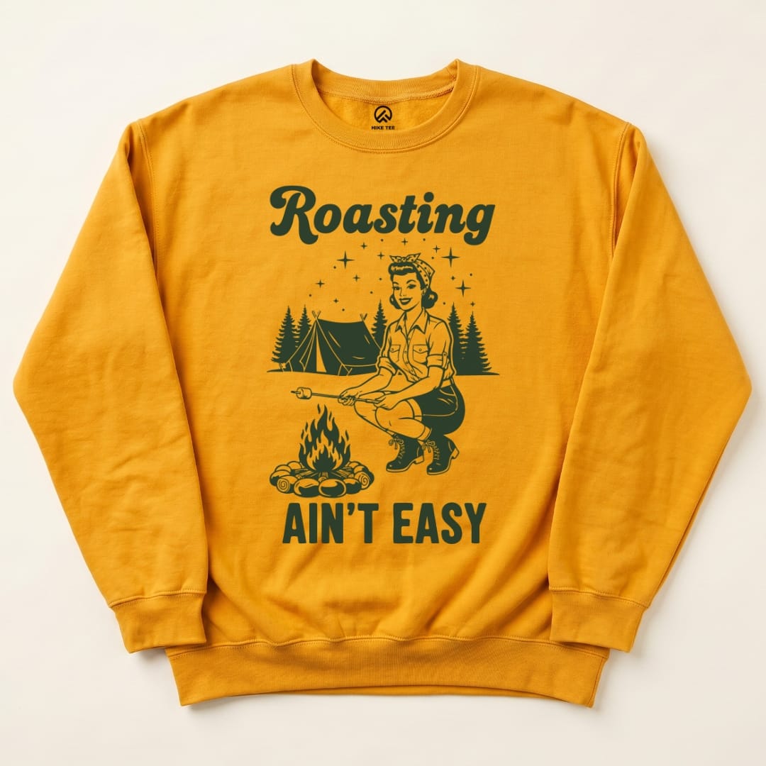 A bright yellow "Roasting Retro Sweatshirt" features a graphic of a woman roasting marshmallows by a campfire with the slogan "Roasting Ain't Easy.