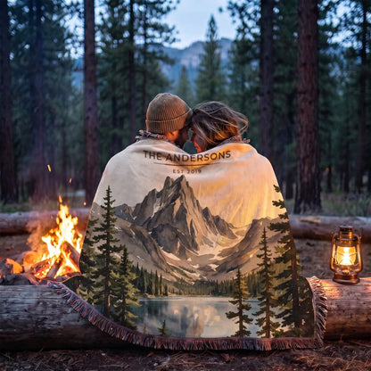 Couple wrapped in the Rocky Mountain Dream Lake Woven Blanket by a campfire