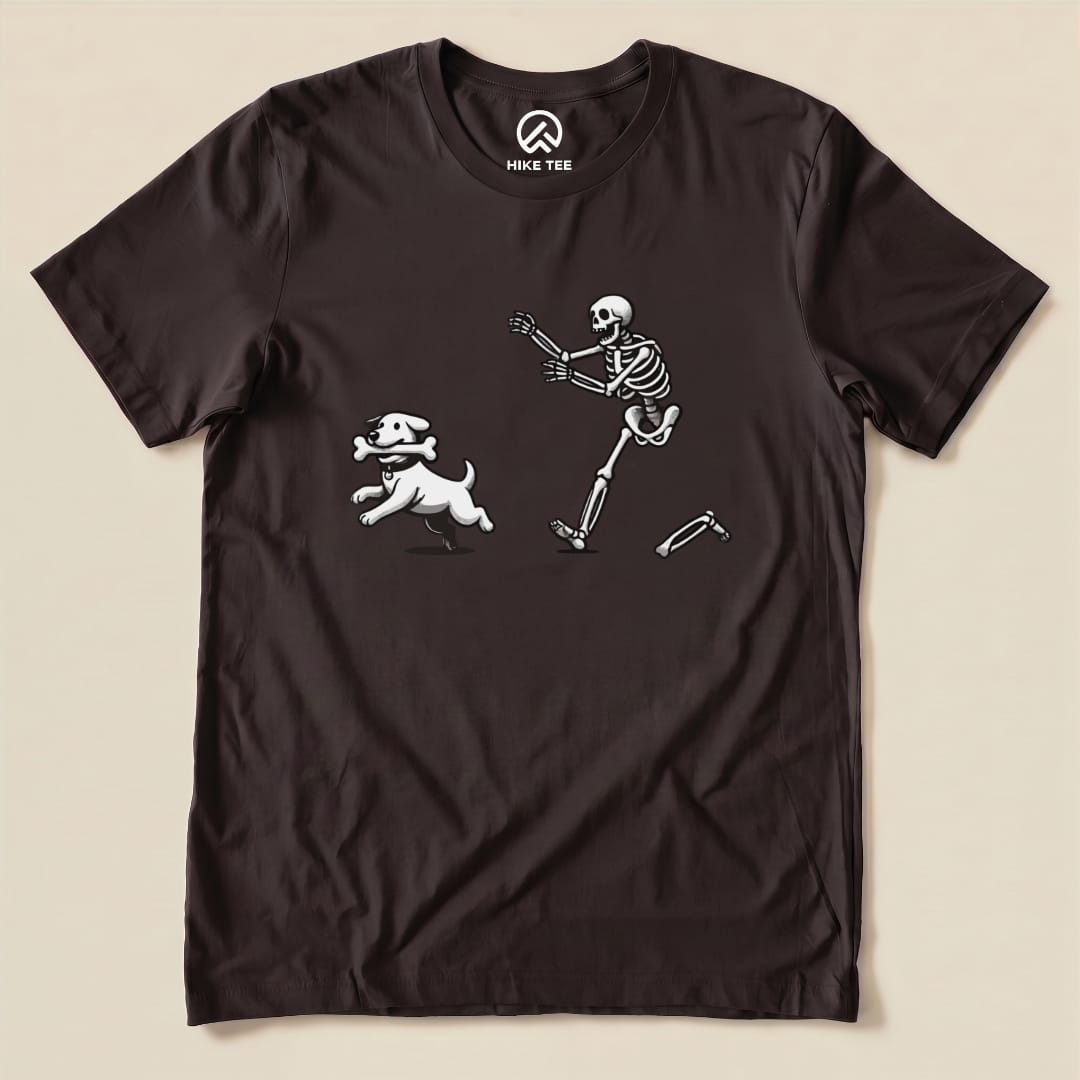 A graphic t-shirt featuring a whimsical design of a skeleton running alongside a playful dog, labeled as "Skeleton and Dog Shirt.