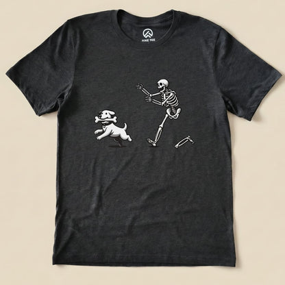 A graphic t-shirt featuring a playful skeleton running alongside a cartoon dog holding a bone, designed as the "Skeleton and Dog Shirt.
