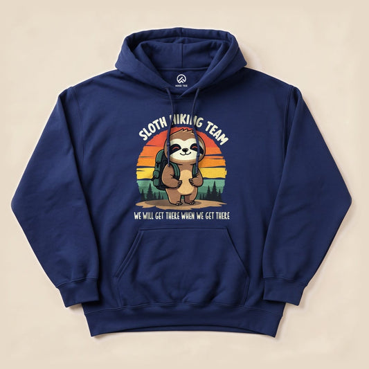 A navy "Sloth Hiking Team Forest Hoodie" features a cartoon sloth with a backpack, surrounded by a sunset and trees, with the slogan "WE WILL GET THERE WHEN WE GET THERE.