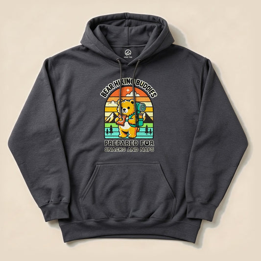 A dark gray hoodie featuring a playful bear graphic, holding a camping backpack with the text "Prepared for Snacks and Naps Hiking Bear Hoodie.