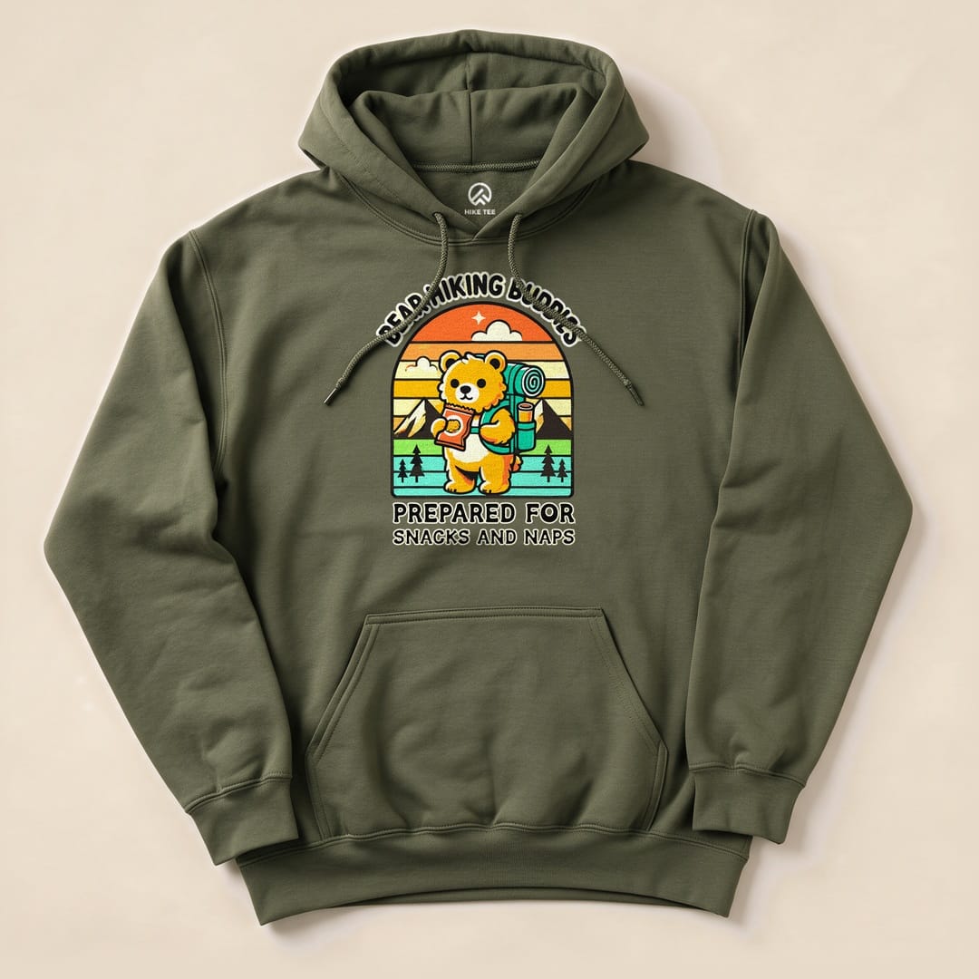 A green hoodie featuring a playful bear graphic with a backpack, reading “Prepared for Snacks and Naps Hiking Bear Hoodie.”