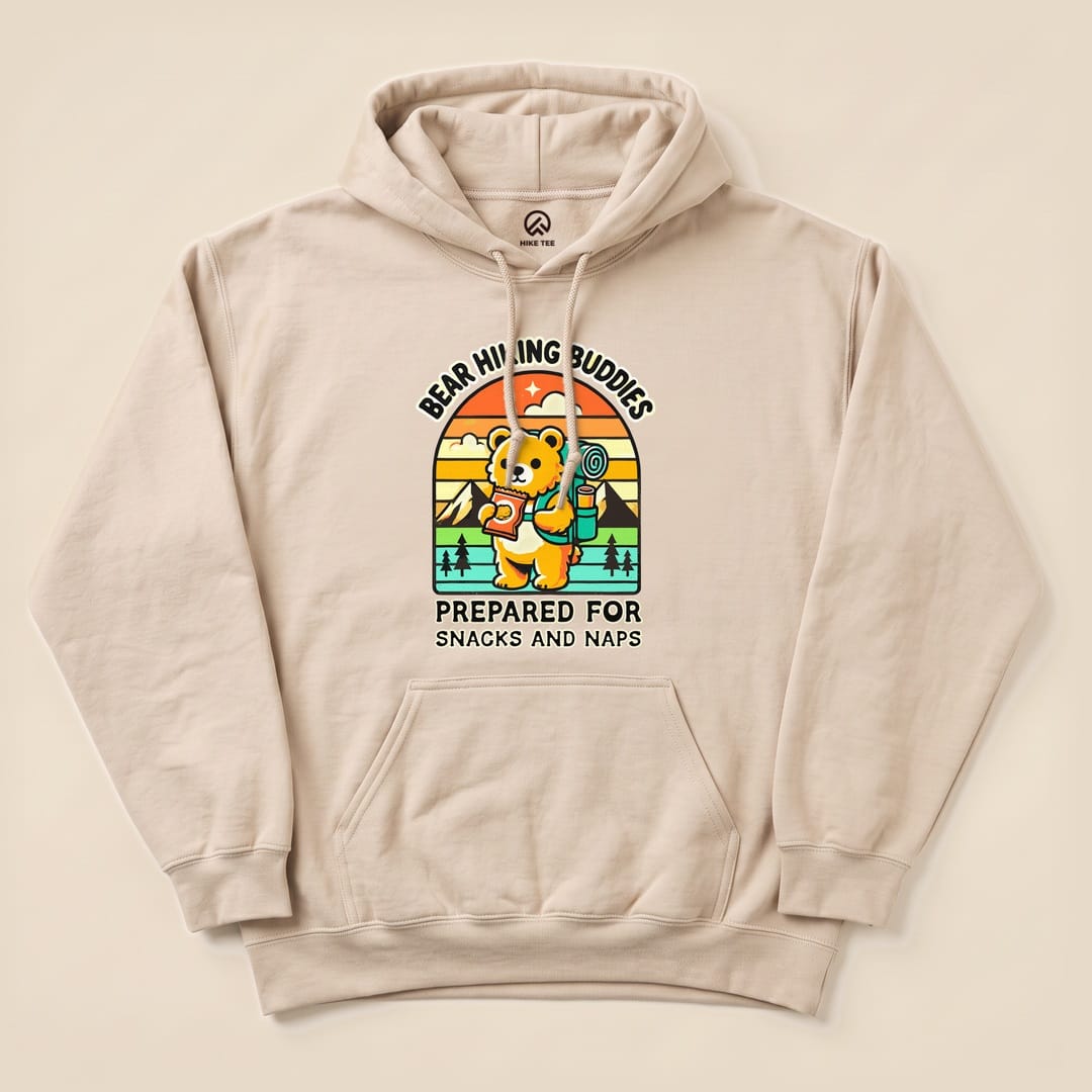 A beige hoodie featuring a cartoon bear holding snacks and a backpack, with the text "Prepared for Snacks and Naps Hiking Bear Hoodie.