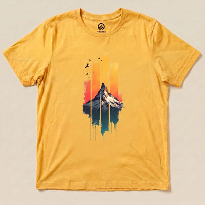The Snow Mountain Sunset Shirt features a vibrant graphic of a snowy mountain against a colorful sunset, set on a yellow background.