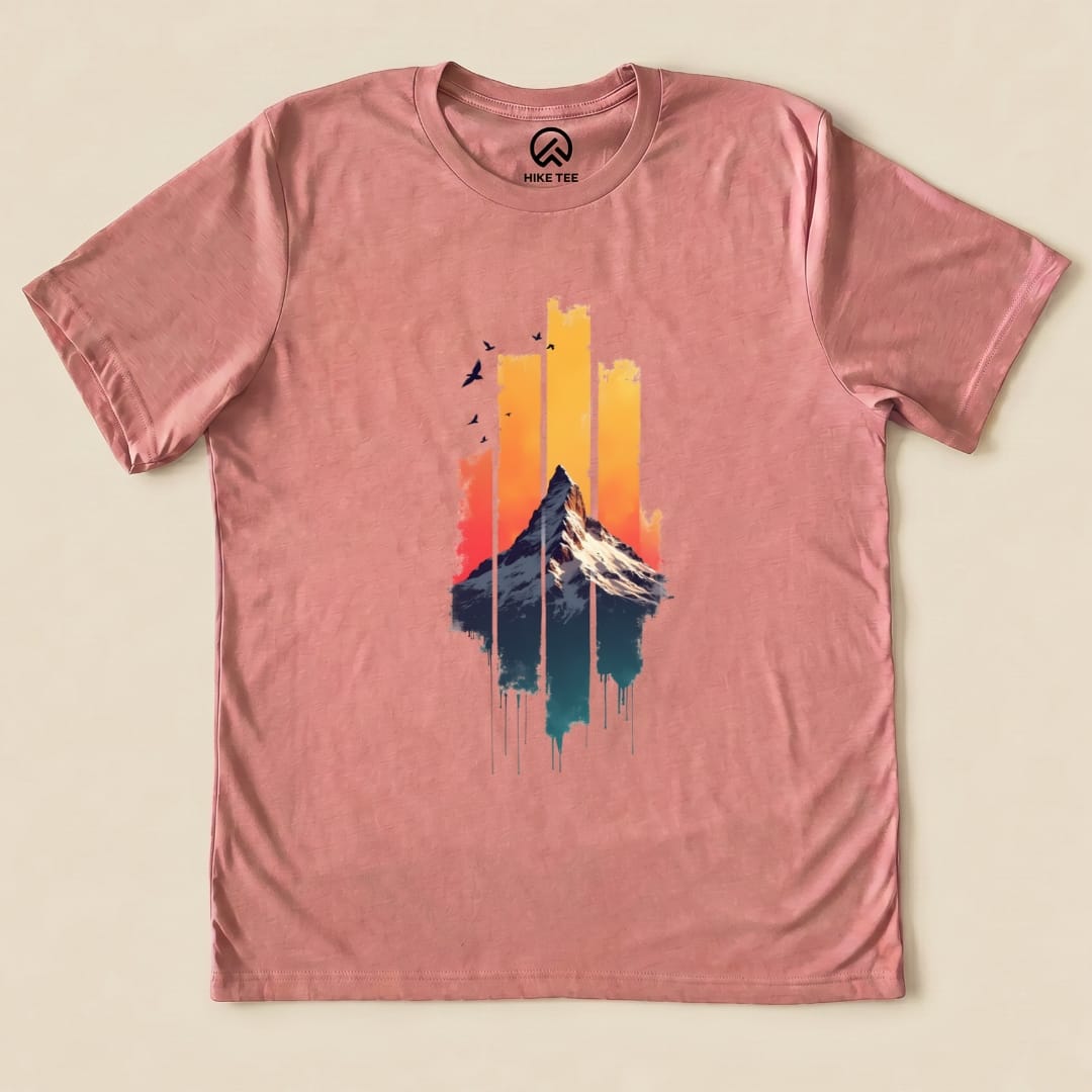 A graphic t-shirt featuring a colorful design of a snow-capped mountain against a vibrant sunset, titled "Snow Mountain Sunset Shirt.