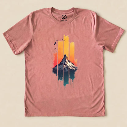 A graphic t-shirt featuring a colorful design of a snow-capped mountain against a vibrant sunset, titled "Snow Mountain Sunset Shirt.