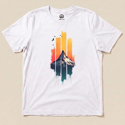 A flat white graphic t-shirt featuring a vibrant sunset design with a snow-capped mountain and colorful vertical stripes, labeled "Snow Mountain Sunset Shirt".