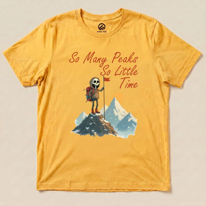 A graphic t-shirt featuring a skeleton hiker on a mountain with the phrase "So Many Peaks So Little Time" printed in bold letters.
