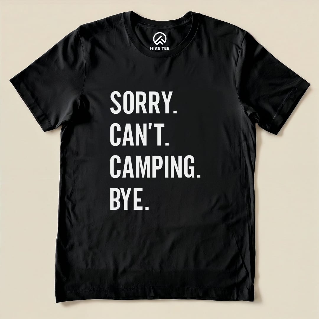 A black graphic t-shirt featuring bold white text reading "Sorry. Can't. Camping. Bye." displayed flat on a neutral background.