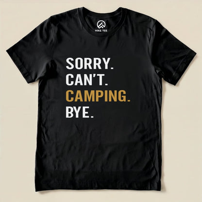 A flat black graphic t-shirt features the text "Sorry. Can't. Camping. Bye." in bold white and gold lettering.