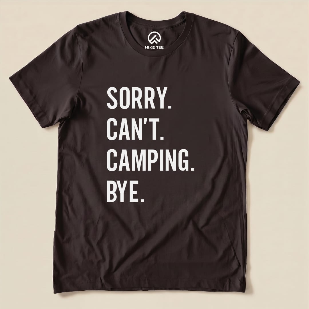 Black graphic t-shirt featuring the text "Sorry. Can't. Camping. Bye." in bold white letters, showcasing a humorous outdoor theme.