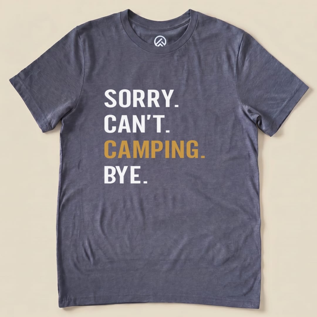Graphic t-shirt featuring the slogan "Sorry. Can't. Camping. Bye." printed in bold white and gold letters on a gray fabric.