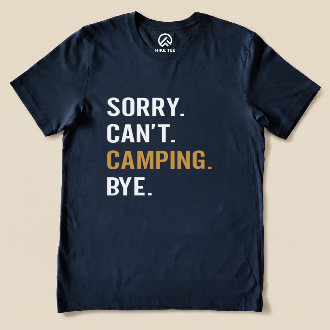 A navy graphic t-shirt features the phrase "Sorry. Can't. Camping. Bye." in bold white and gold lettering.