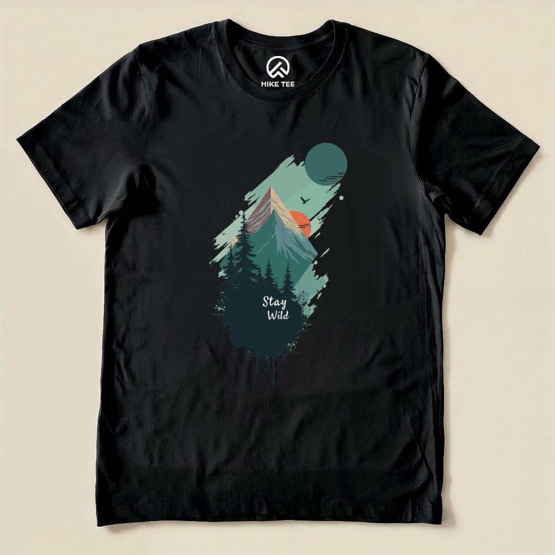 A black graphic t-shirt featuring a mountain scene, trees, and the phrase "Stay Wild" printed prominently below.
