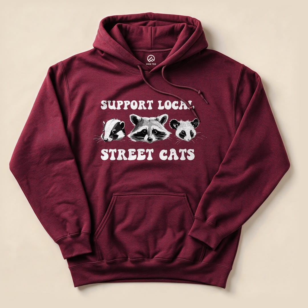 A maroon Street Cats Hoodie features a graphic of a badger, raccoon, and panda with the phrase "Support Local Street Cats" printed above.