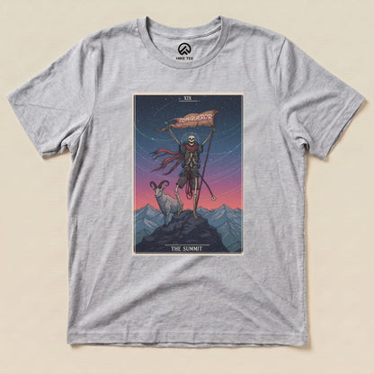 A graphic t-shirt featuring the "Summit Tarot Card Shirt" design, showcasing a skeleton holding a flag and a goat on a mountain.