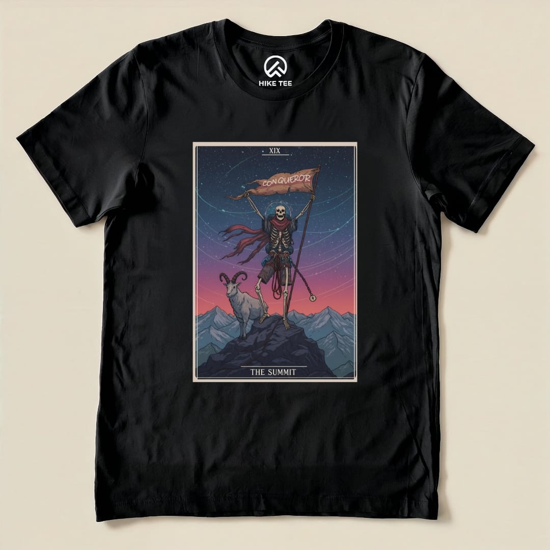 A black graphic t-shirt featuring a colorful design of a skeleton holding a flag that reads "CONQUEROR" next to a goat, titled "The Summit.