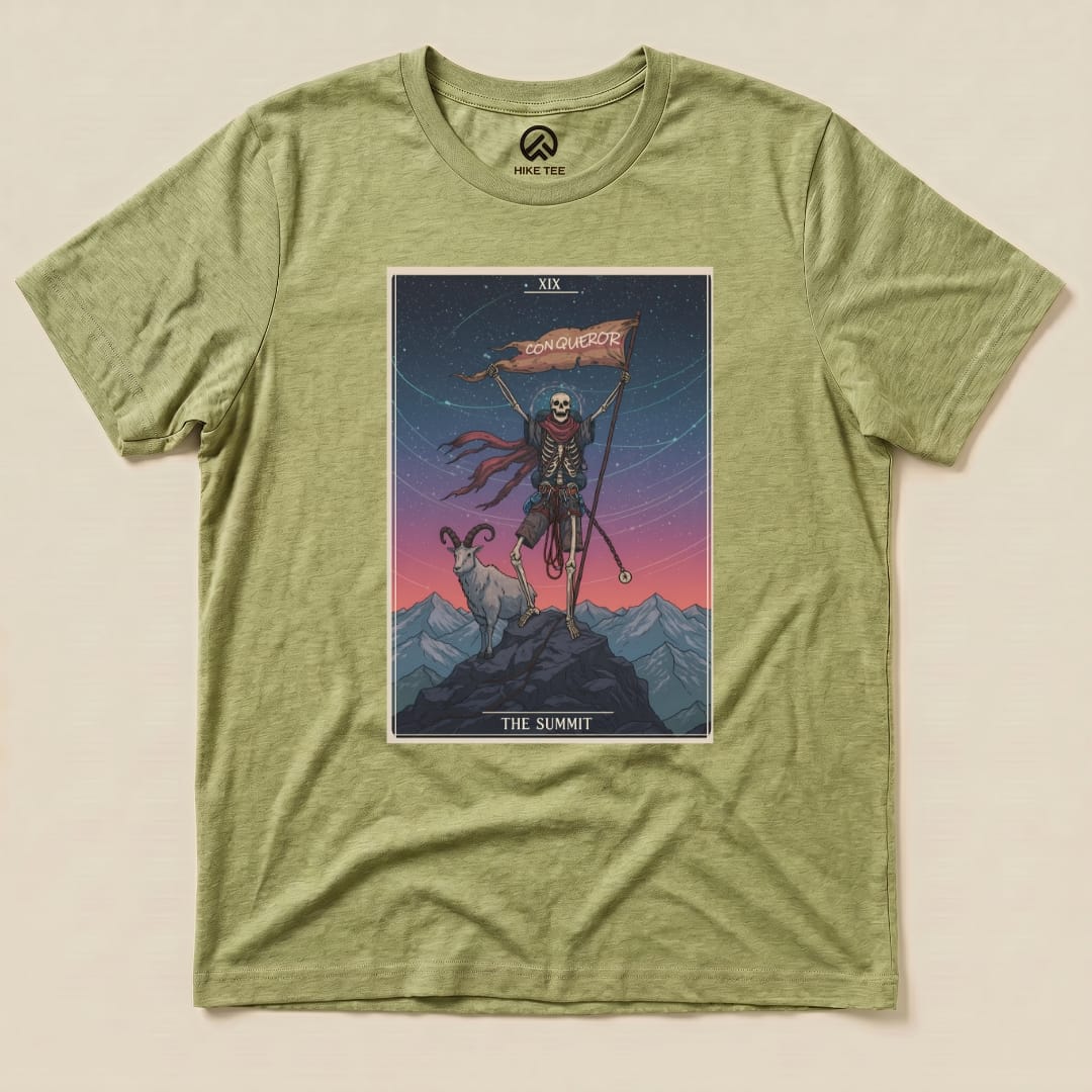 The graphic t-shirt features a tarot card design with a skeleton holding a flag labeled "Conqueror" and standing on a mountain with a goat, titled "The Summit.