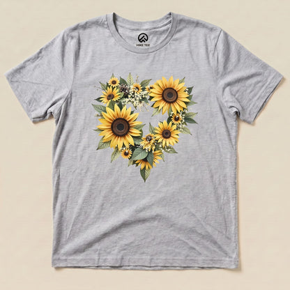 A gray graphic t-shirt featuring a heart design made of sunflowers and greenery, labeled as "Sunflowers Heart Shirt.