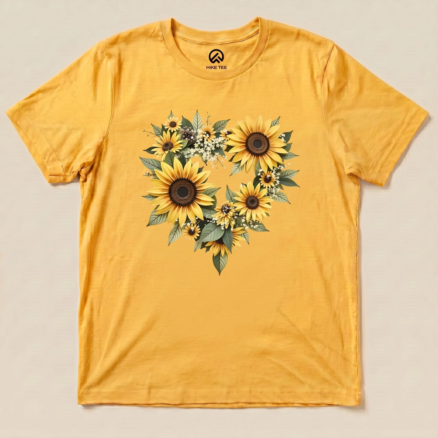 The Sunflowers Heart Shirt features a vibrant yellow fabric adorned with a heart-shaped arrangement of sunflowers and greenery.