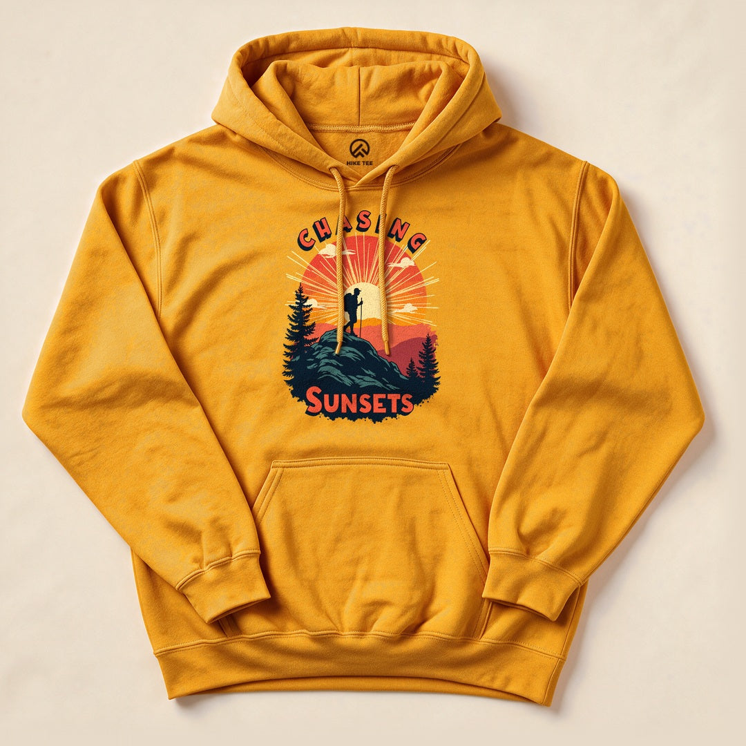 Gold Chasing Sunsets Hoodie with a hiker on a mountain at sunset