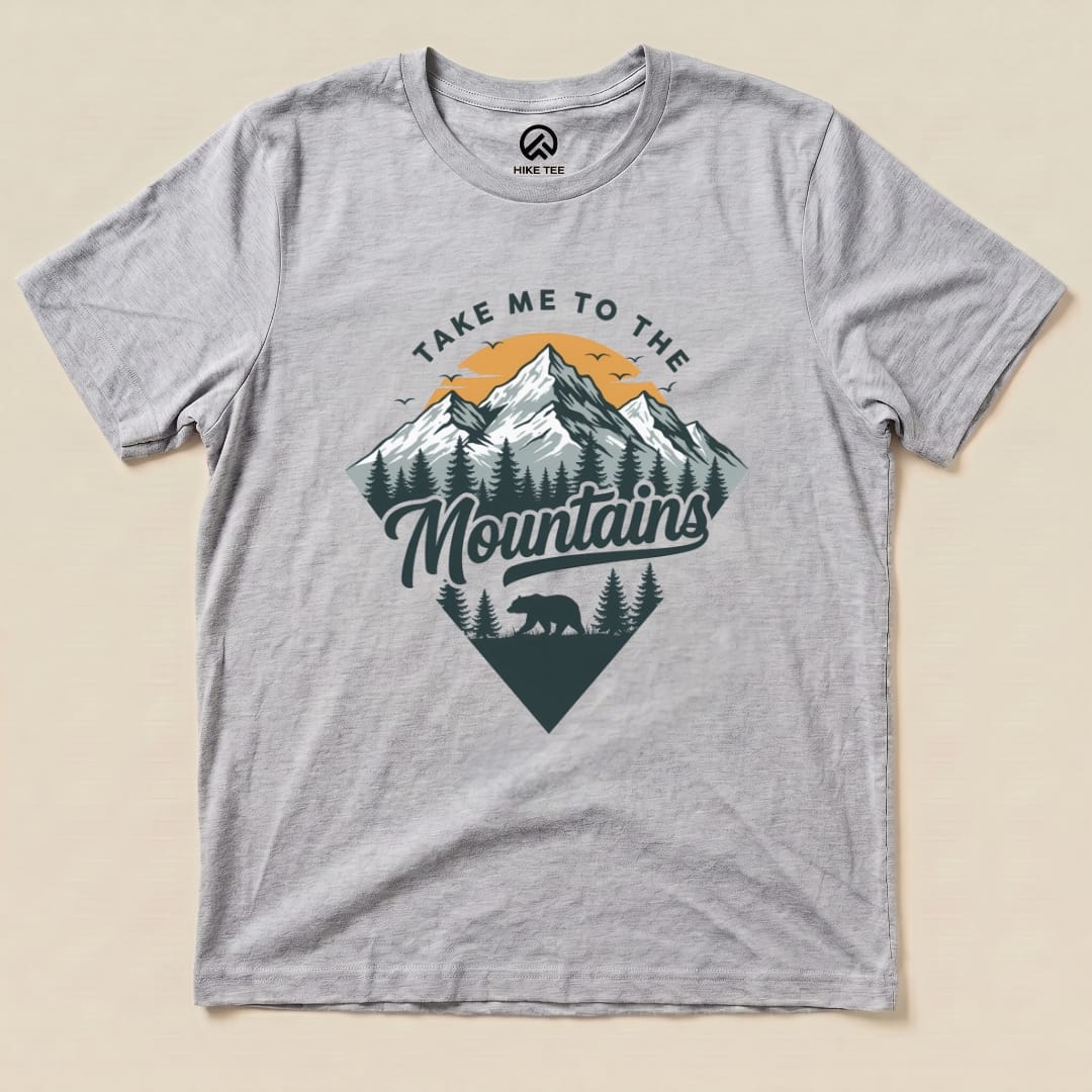 The gray graphic t-shirt features a mountain landscape design with the phrase "Take Me To The Mountains" and a silhouette of a bear.