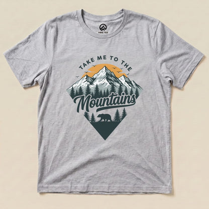 The gray graphic t-shirt features a mountain landscape design with the phrase "Take Me To The Mountains" and a silhouette of a bear.