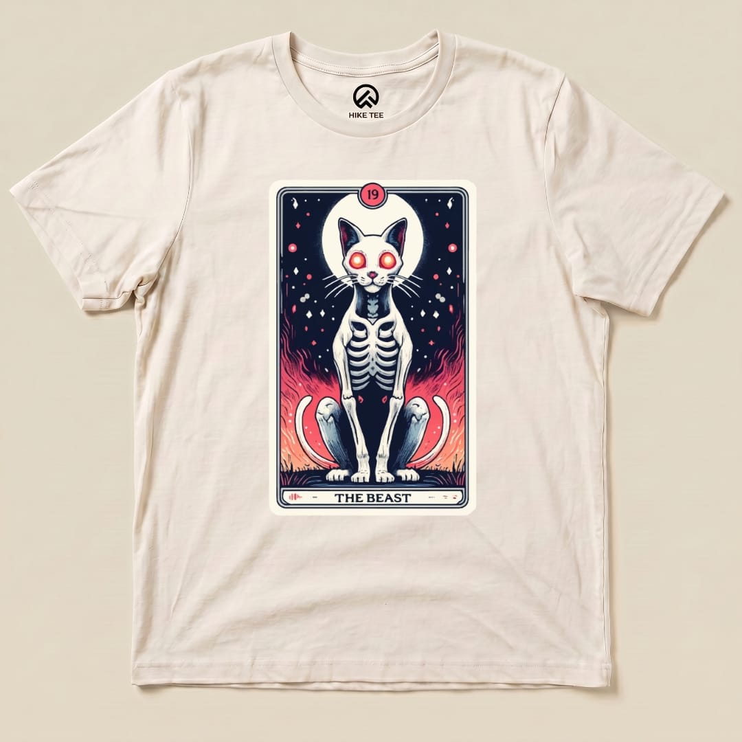 A graphic t-shirt featuring "The Beast Tarrot Cat shirt" with a skeletal cat design surrounded by vibrant flames and stars.