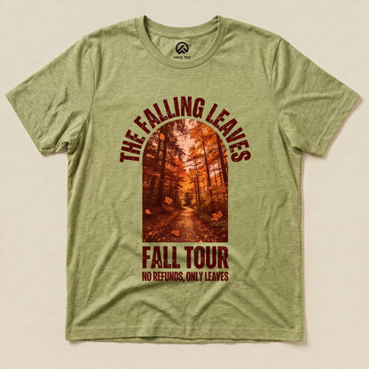 The Falling Leaves Fall Tour Shirt features a vibrant autumn scene with a forest pathway and falling leaves, printed on a green graphic t-shirt.