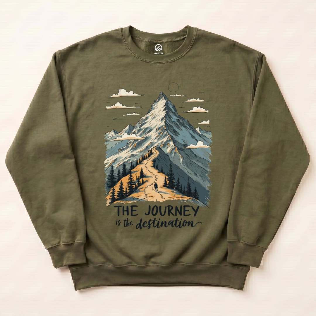 A graphic t-shirt in olive green featuring a mountain illustration and the slogan "THE JOURNEY is the destination.