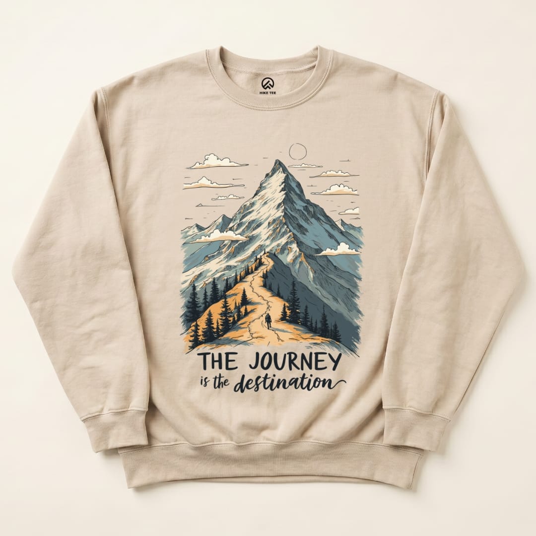 A beige sweatshirt featuring a mountain graphic and the slogan "THE JOURNEY is the destination," highlighting hiking themes.