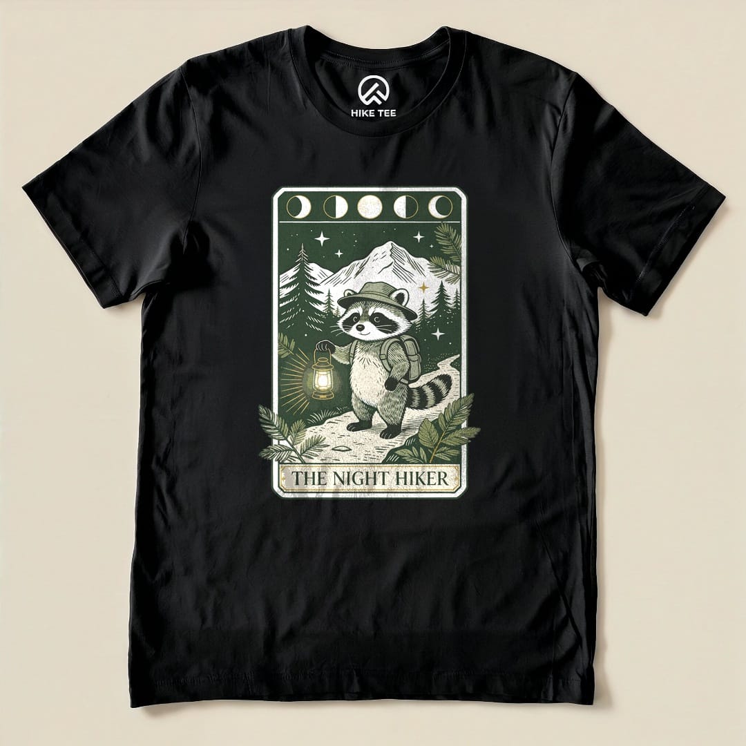 Black The Night Hiker Shirt with a raccoon hiker with a lantern on a moonlit tarot card graphic